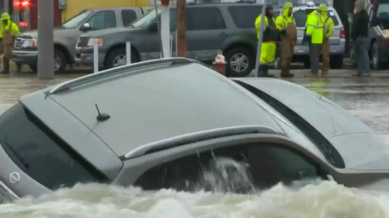 Ohio city worker rescues a mother and her two children from a submerged car caught in a sinkhole.