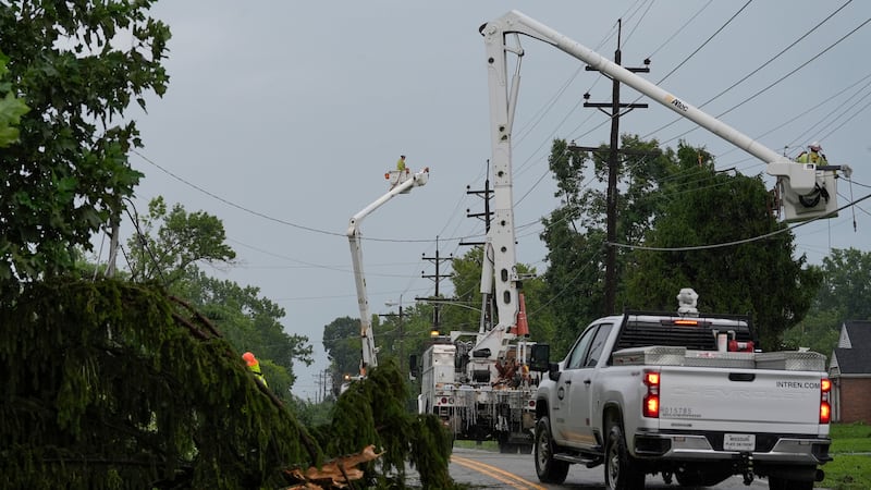 Crews work along Race Road among trees and power lines downed by severe storms on Tuesday, to...