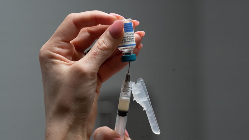 Lauren Ellenburg, a nurse, prepares a combination measles, mumps and rubella vaccine for a...