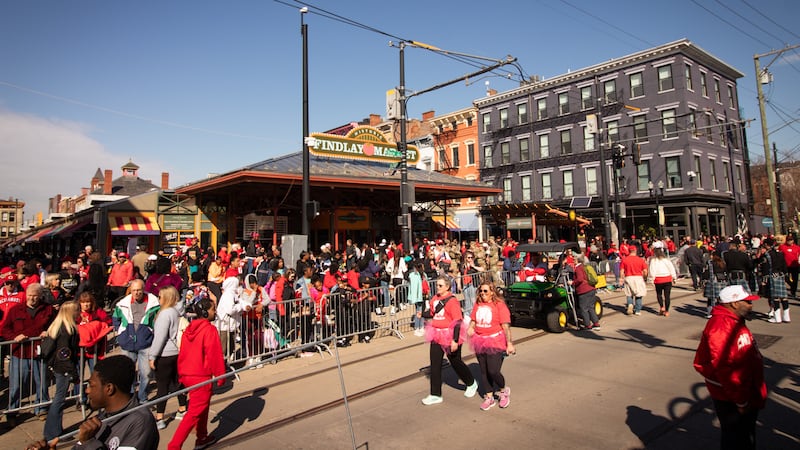 Parade participants and viewers scramble through Findlay Market on Opening Day.