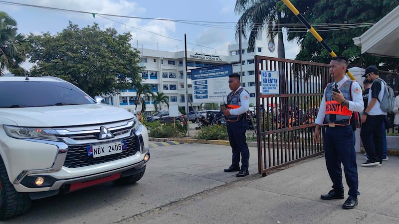Security guards keep watch as vehicles exit the Ateneo de Zamboanga University following a...