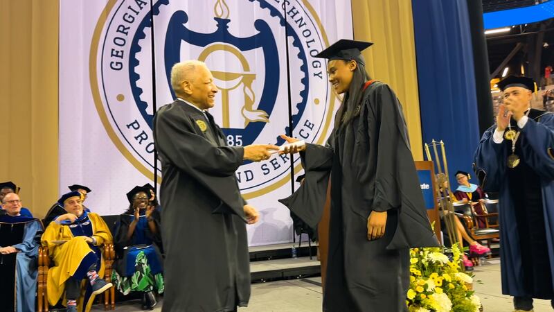 Ronald Yancey, Georgia Tech's first black graduate, handed Deanna Yancey, his granddaughter,...