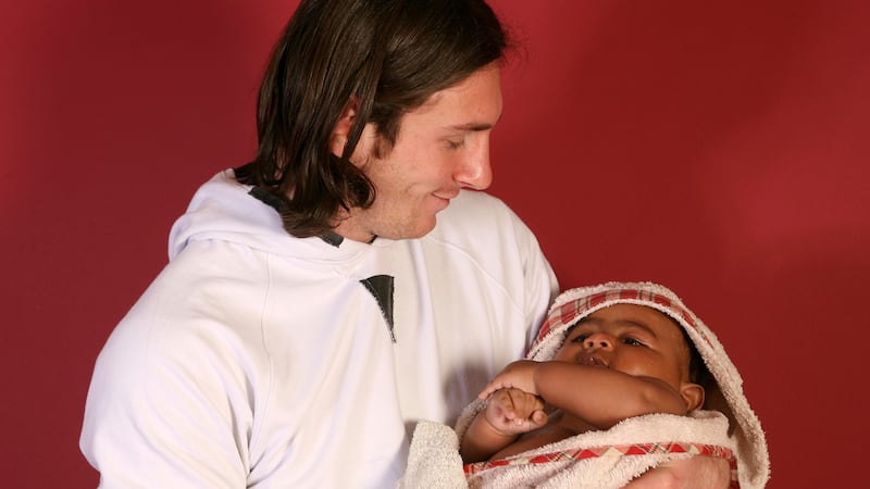 20-year-old soccer star Lionel Messi cradles Lamine Yamal, who was merely six months old at...