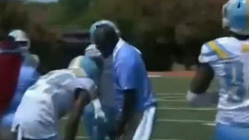 A high school football player is bent over after an apparent punch from a coach Saturday...
