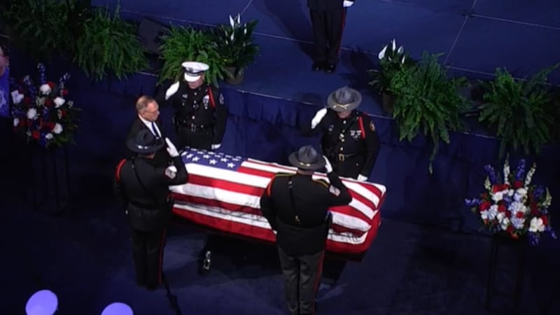 Deputy Larry Henderson's casket carried into the Cintas Center one week after his death on May...