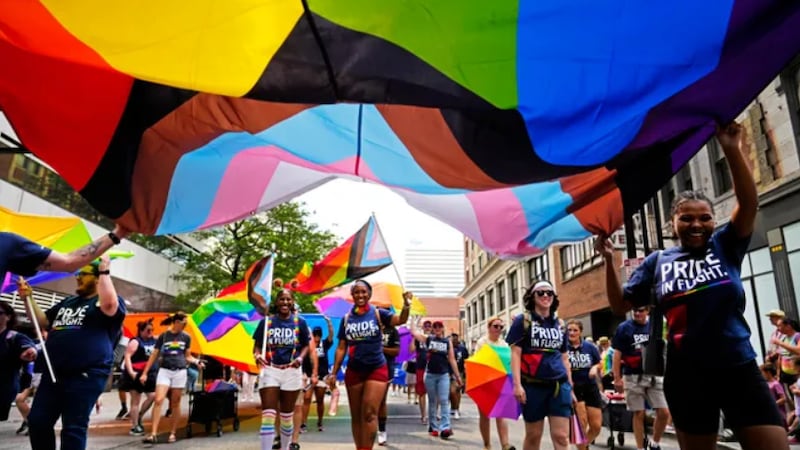 A group representing Delta Airlines, carries a large flag during the 51st Cincinnati Pride...