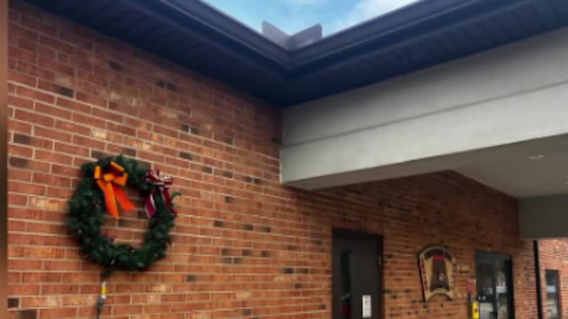 Outside the Colerain Fire Department sits a large wreath decorated with red light bulbs. Each...