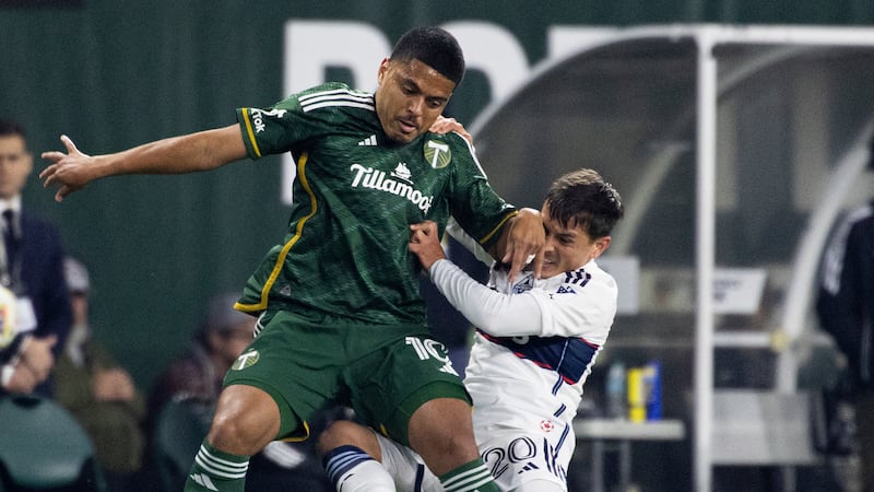 Vancouver Whitecaps midfielder Andrés Cubas, right, grabs Portland Timbers midfielder Evander,...
