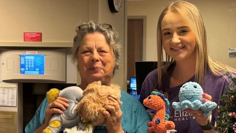 Two healthcare workers are handmaking stuffed animals to comfort children visiting the...