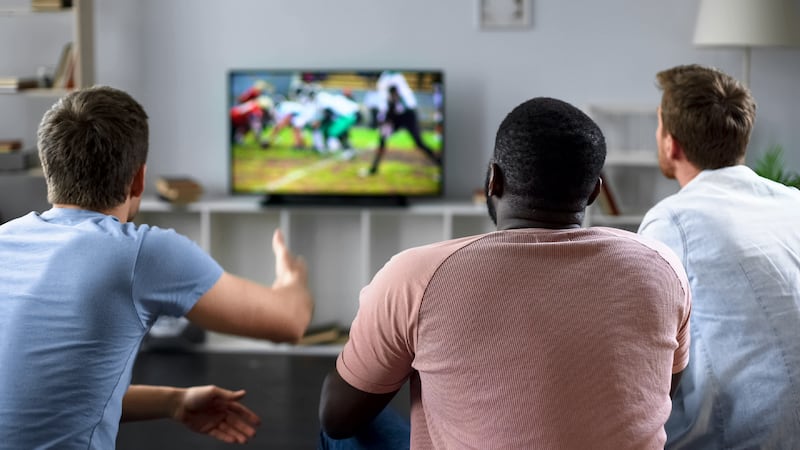 NextGenTV Sports - Male friends gather to watch football competition on big screen, sofa experts